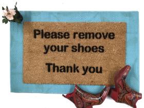 doormat reading Please remove your shoes Thank You on a blue layering rug with p