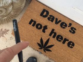 Brown coir doormat printed "Dave's not here" — funny 420 friendly welcome mat for weed lovers