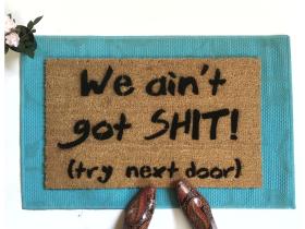 Coir doormat printed with 'We Ain't Got Shit! Try Next Door' funny welcome mat for front porch