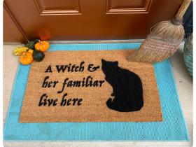 Black witch and cat familiar Halloween doormat on covered porch