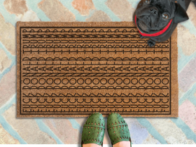 A pair of feet wearing green shoes stands on a subtle patterned FDT Fuck Donald Trump doormat