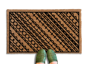 A pair of feet wearing green shoes stands on a subtle patterned FDT Fuck Donald Trump doormat