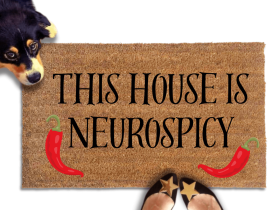 cute dog peeking over a doormat reading "This house is neurospicy" with red chili peppers on it