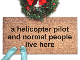 large door mat reading "a helicopter pilot and normal people live here" with a christmas wreath and woman in smurf blue boots