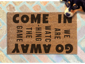 Come In / Go Away, We're watching the game door mat pictured with a shepard dog looking up