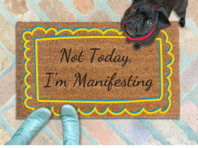 outside coir door mat reading "not today, I'm manifesting" on a red brick patio with a black pug puppy looking up and a woman's feet in smurf blue boots