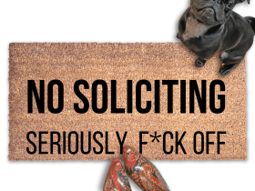 outside coir door mat reading "NO SOLICITING, Seriously Fuck Off."  with a black pug puppy looking up and a woman's feet in smurf blue boots