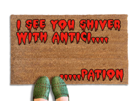Rocky Horror Movie Quote "I see you shiver with anticipation" doormat written in red bloody letters. A person in green shoes stands on the mat