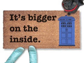 Blue TARDIS police box doormat reading Bigger On The Inside on a front porch